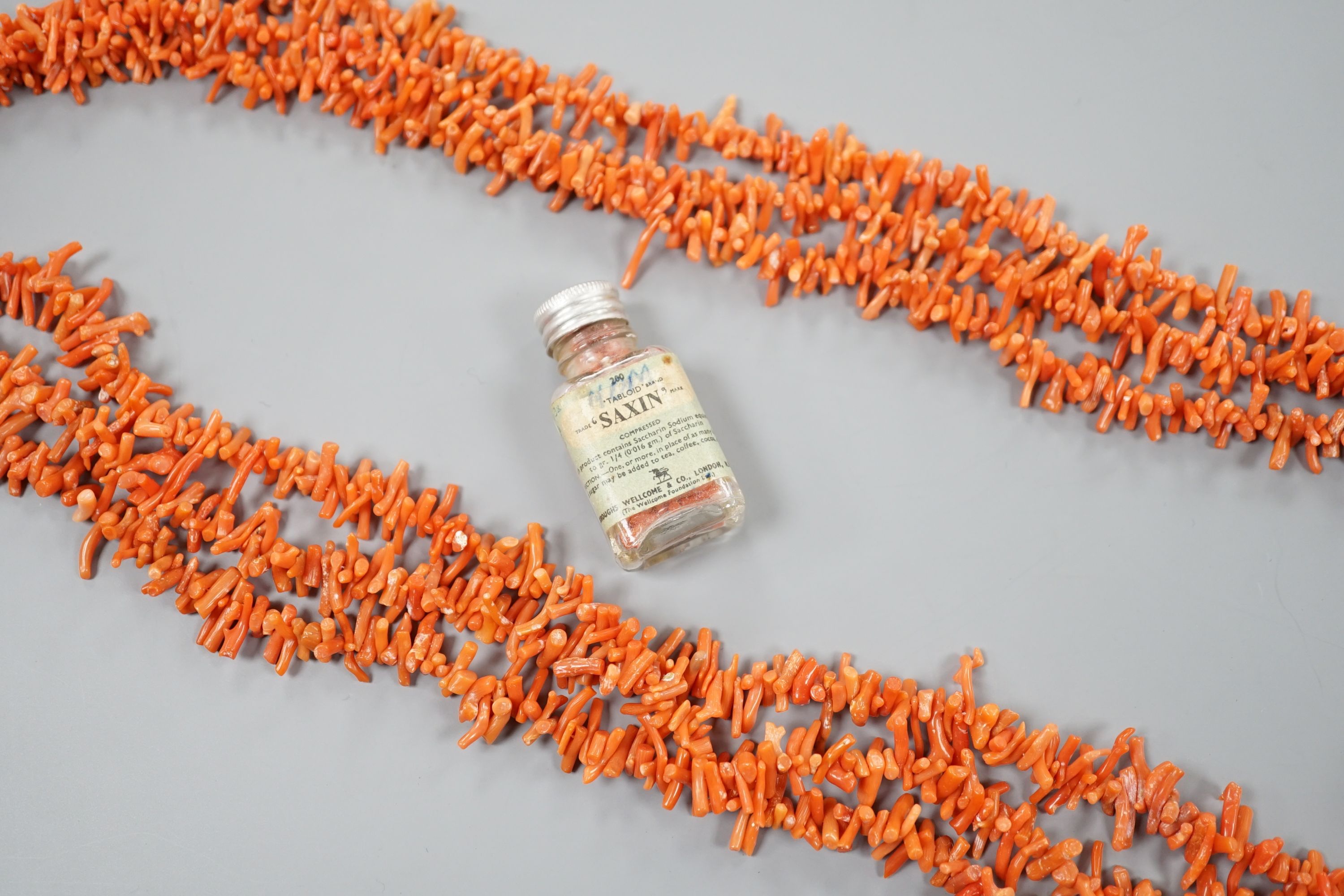 A triple strand branch coral necklace, 86cm, gross weight 141 grams and a small jar of loose branch coral.